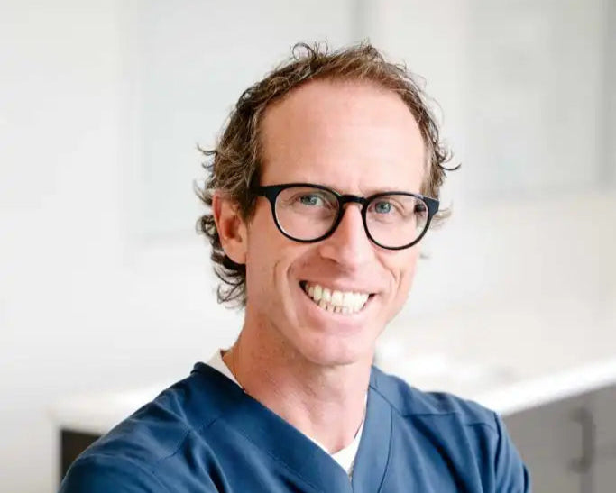 Person wearing blue scrubs in a clinical setting